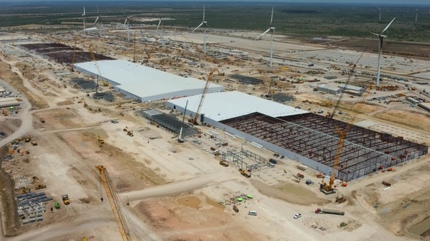 Aerial view of industrial building construction site with wind turbines