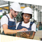 Two people in hardhats working on a tablet